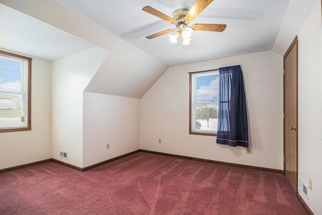 additional living space with vaulted ceiling, carpet floors, visible vents, and a healthy amount of sunlight