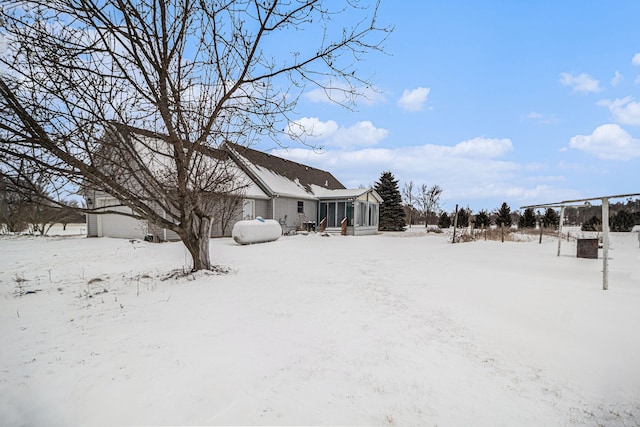 yard layered in snow with a sunroom