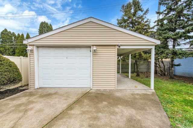 detached garage with a carport, concrete driveway, and fence