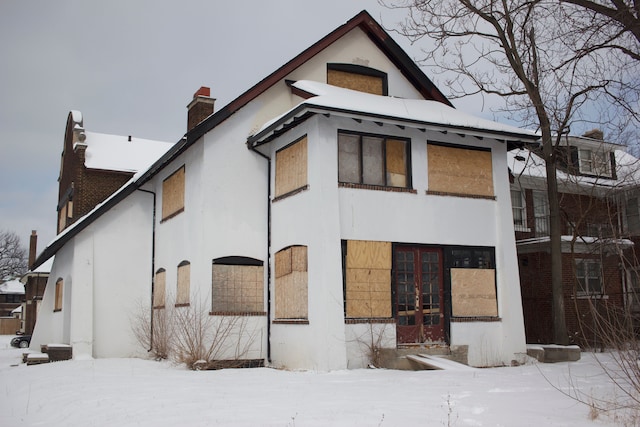 snow covered rear of property featuring french doors