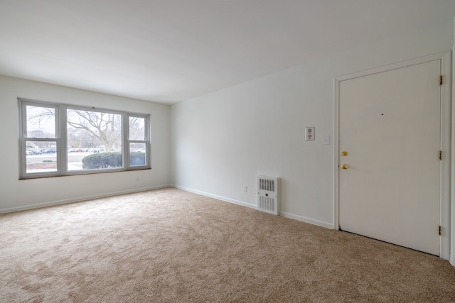 spare room featuring baseboards, carpet flooring, and heating unit