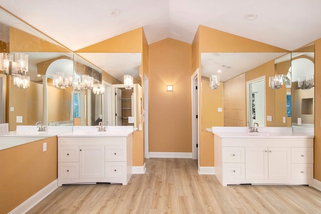 bathroom featuring lofted ceiling, wood-type flooring, and vanity