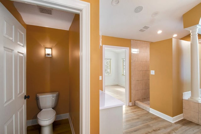 bathroom with hardwood / wood-style flooring, decorative columns, and toilet