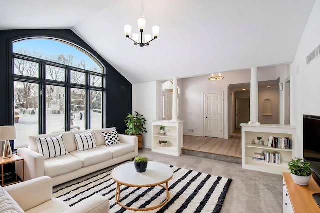 carpeted living room with high vaulted ceiling and an inviting chandelier