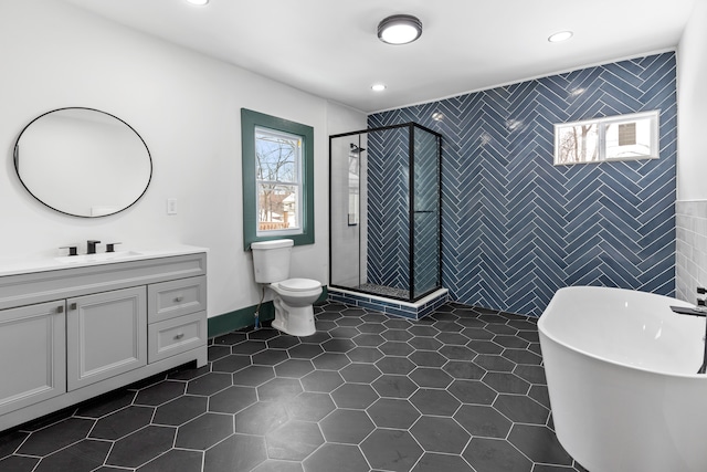 full bathroom featuring tile walls, tile patterned flooring, shower with separate bathtub, and vanity