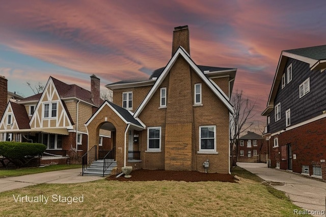 4767 Sturtevant St, Detroit, MI 48204 - tudor home featuring brick siding, a front yard, and a chimney