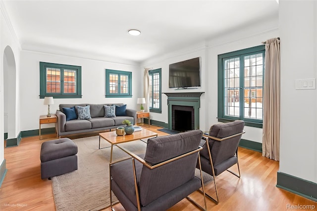 4767 Sturtevant St, Detroit, MI 48204 - living area featuring arched walkways, a fireplace, light wood-type flooring, and ornamental molding