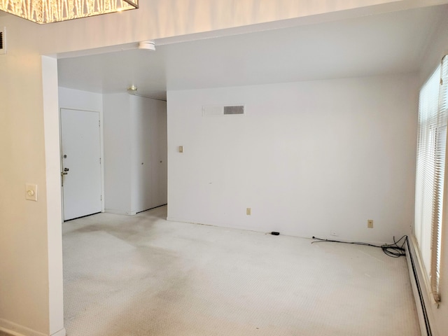 carpeted empty room featuring a baseboard radiator