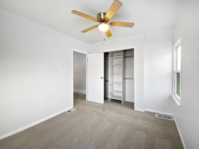 unfurnished bedroom featuring carpet, a closet, and ceiling fan