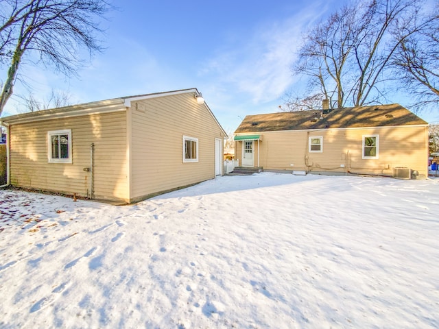 snow covered property with central AC unit