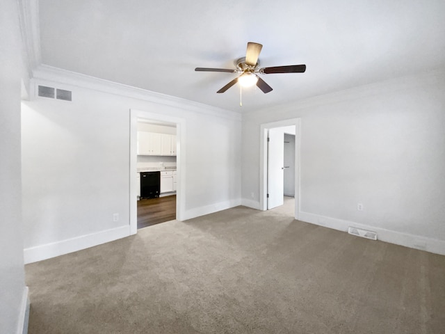 carpeted spare room with ceiling fan and crown molding