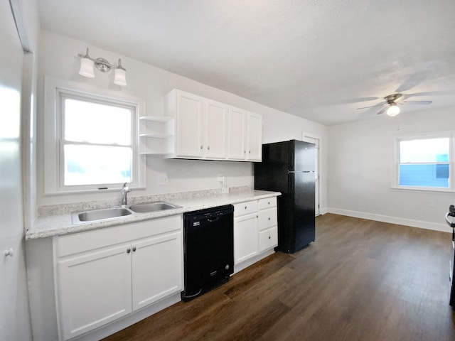 kitchen with a wealth of natural light, sink, white cabinetry, and black appliances