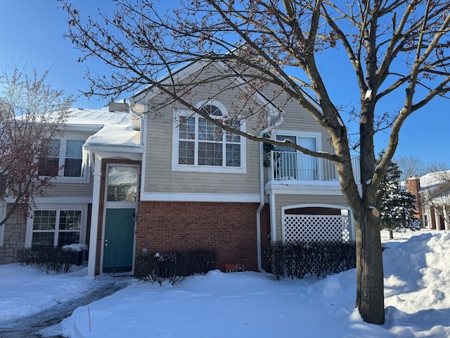 view of front of property featuring brick siding and a balcony