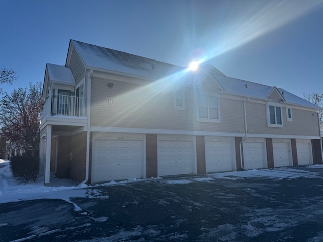 snow covered property with community garages