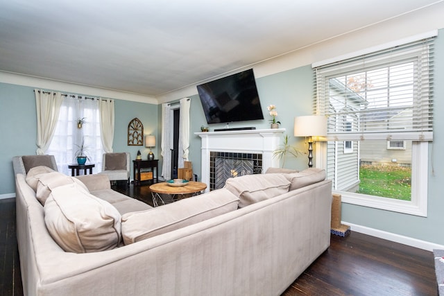 living room with a wealth of natural light, dark hardwood / wood-style floors, and a fireplace