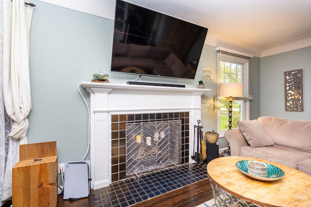 living room featuring hardwood / wood-style flooring and a tile fireplace