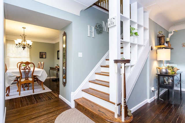 stairs featuring a chandelier, crown molding, and wood-type flooring