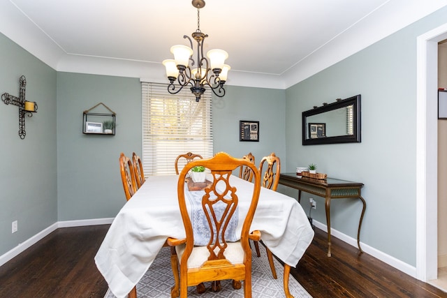 dining room with dark hardwood / wood-style floors and an inviting chandelier