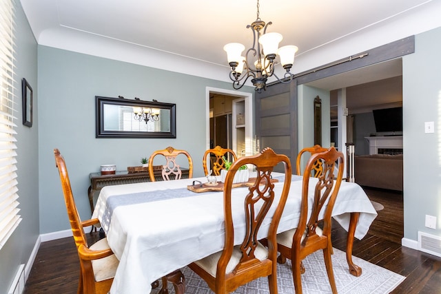 dining area with dark wood-type flooring and a notable chandelier