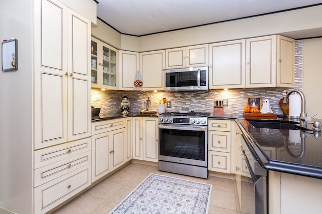 kitchen featuring sink, appliances with stainless steel finishes, cream cabinets, and tasteful backsplash