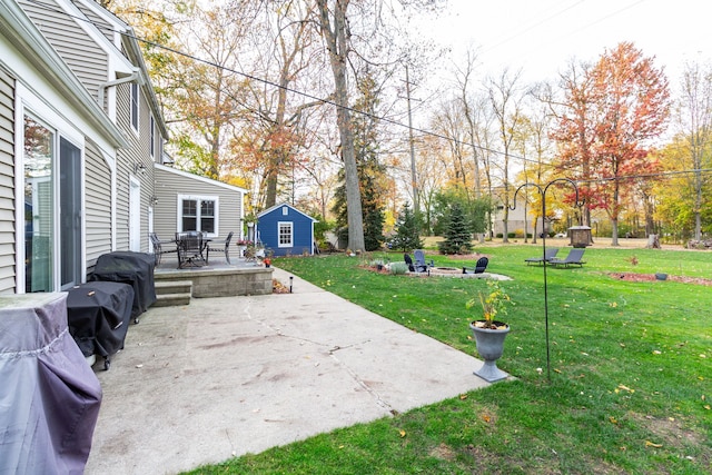 view of yard with a patio area, an outdoor structure, and a fire pit