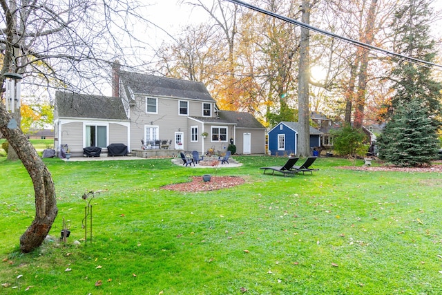 back of house featuring a yard, a fire pit, and a patio area