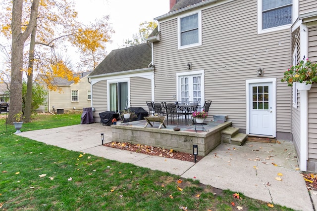 rear view of house with a patio and a lawn