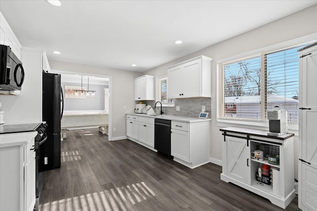 kitchen featuring dark wood-type flooring, sink, white cabinetry, and black appliances