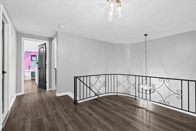 hall with an inviting chandelier and dark wood-type flooring