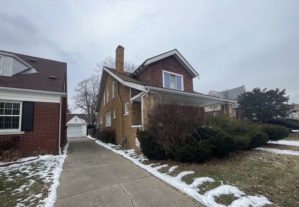 view of snow covered exterior featuring an outdoor structure and a garage