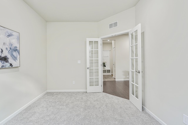 carpeted spare room with french doors