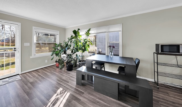 dining space featuring hardwood / wood-style flooring, crown molding, and a textured ceiling