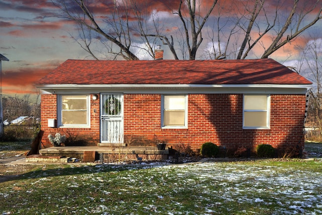 property exterior at dusk with a yard