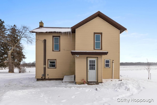 view of snow covered rear of property