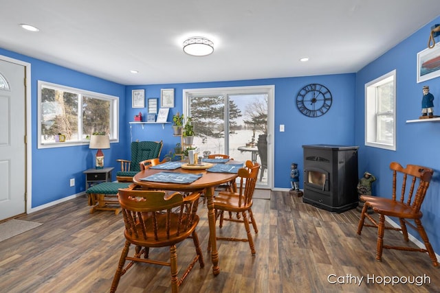 dining space with dark wood-type flooring and a wood stove