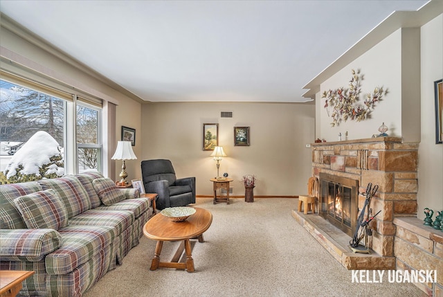 carpeted living room with a stone fireplace