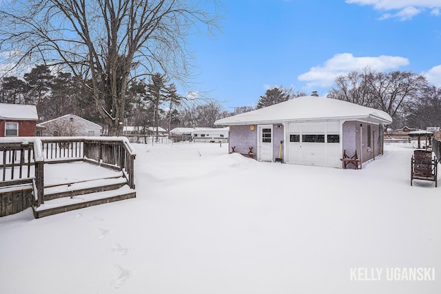 yard covered in snow featuring a garage and an outdoor structure