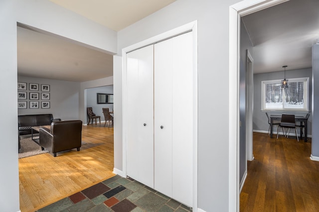 hallway featuring wood finished floors and baseboards