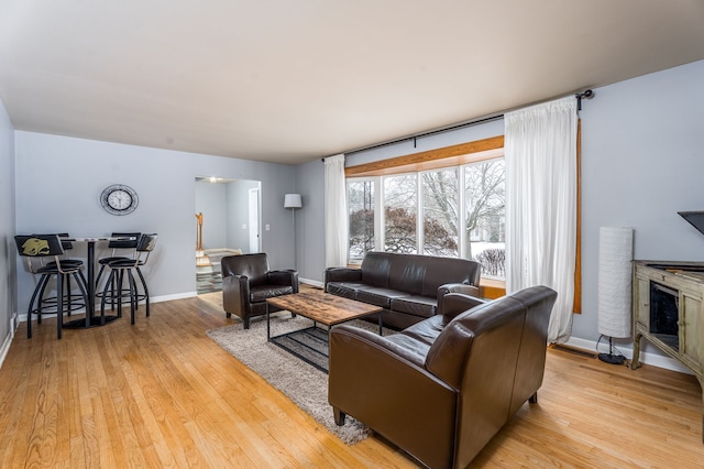 living area featuring light wood finished floors and baseboards