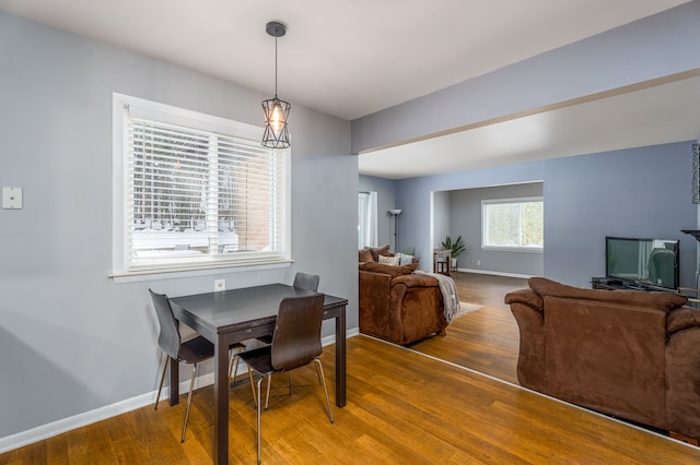 dining space with baseboards and wood finished floors