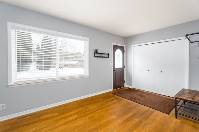 entryway featuring visible vents, baseboards, and wood finished floors