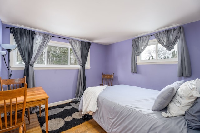 bedroom with baseboards and wood finished floors