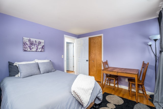 bedroom with a closet, baseboards, and wood finished floors