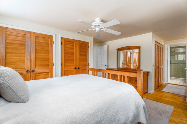 bedroom featuring light wood finished floors, baseboards, a ceiling fan, and multiple closets