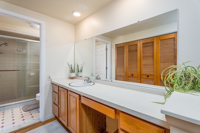 bathroom with a stall shower, vanity, and toilet