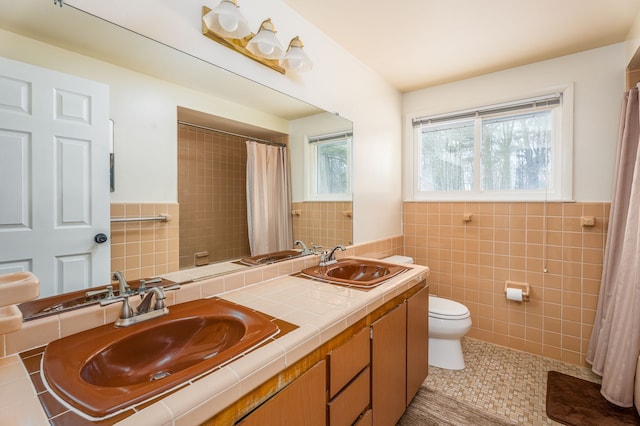 full bathroom with toilet, tile patterned flooring, a sink, and tile walls