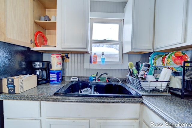 kitchen featuring sink, tasteful backsplash, and white cabinets