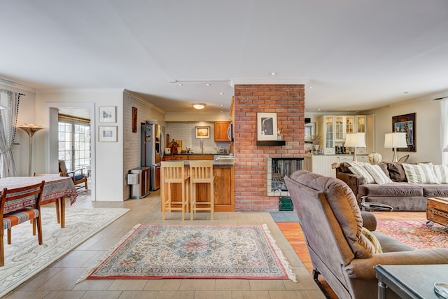 living room featuring recessed lighting, a brick fireplace, and crown molding