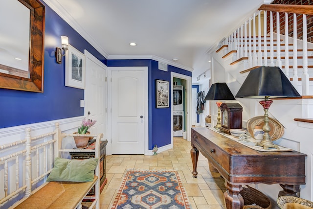 foyer with stacked washer and dryer, baseboards, stairs, stone finish flooring, and crown molding