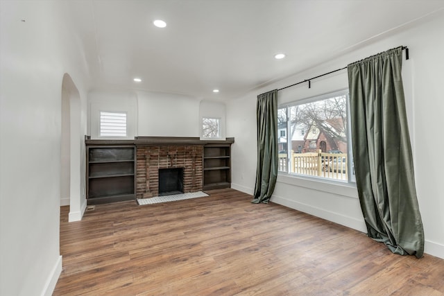 unfurnished living room with a fireplace and hardwood / wood-style floors